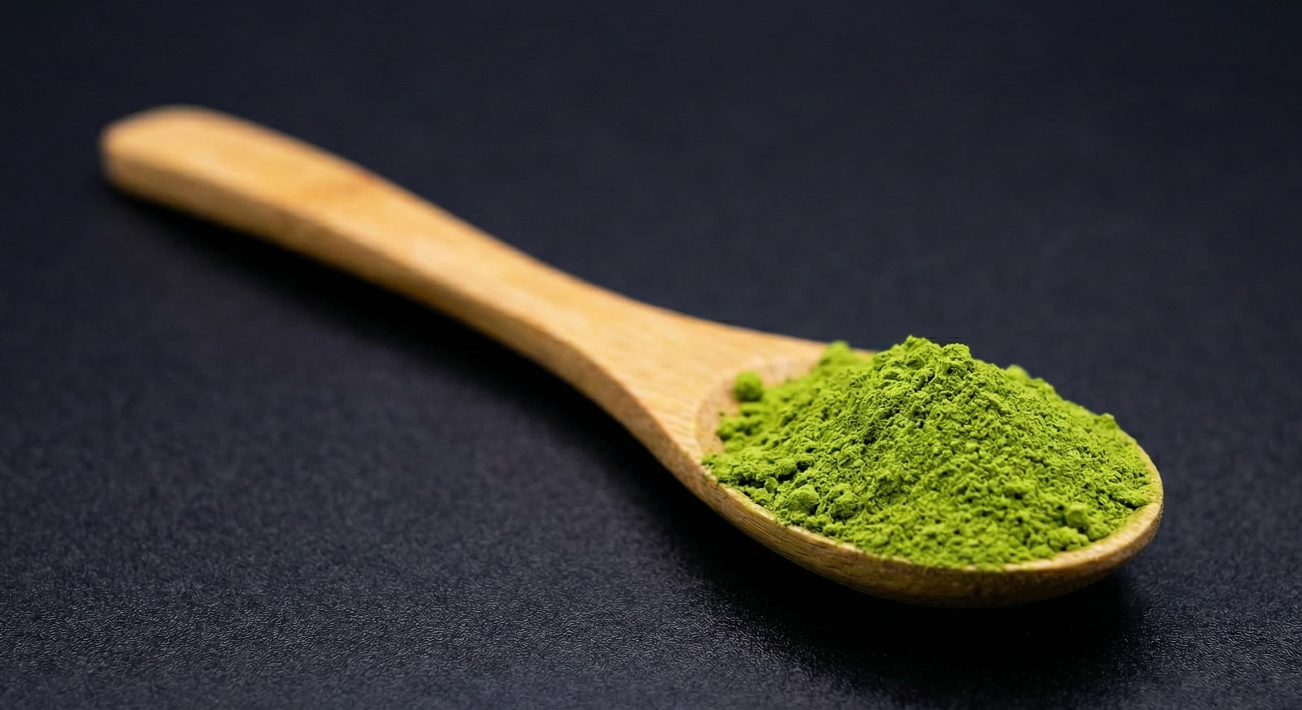 Premium ceremonial grade uji matcha green tea powder close-up on bamboo spoon